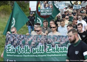 Konstantin Steglich bei der 1. Mai Demo 2025 des III. Wegs in Suhl (mittig direkt hinterm Banner mit Sonenbrille und Schild in der Hand)